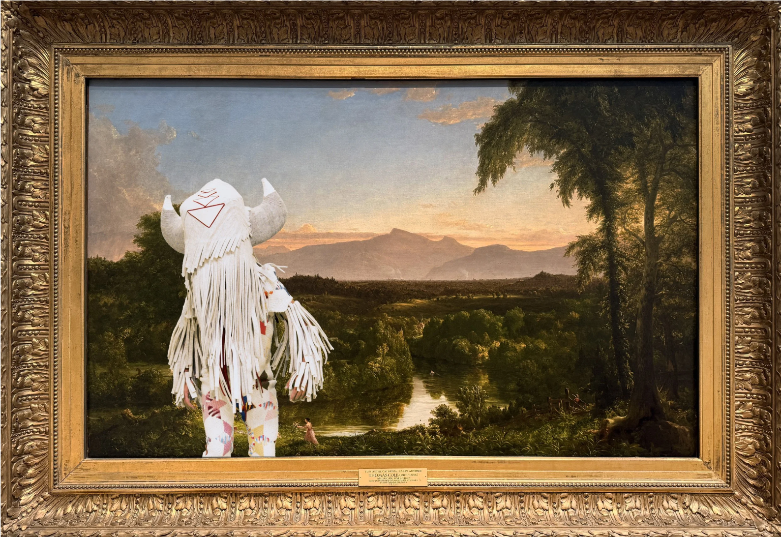 Indigenous person inserted into gold-framed Thomas Cole landscape painting